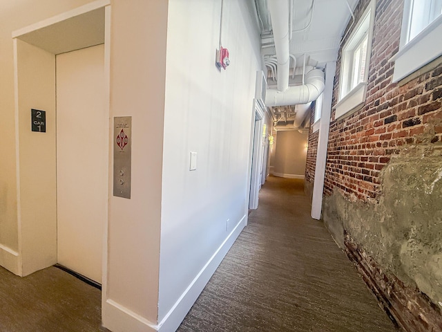 4 Beaufain St Unit 207, Charleston, SC 29401 - hall with brick wall and elevator