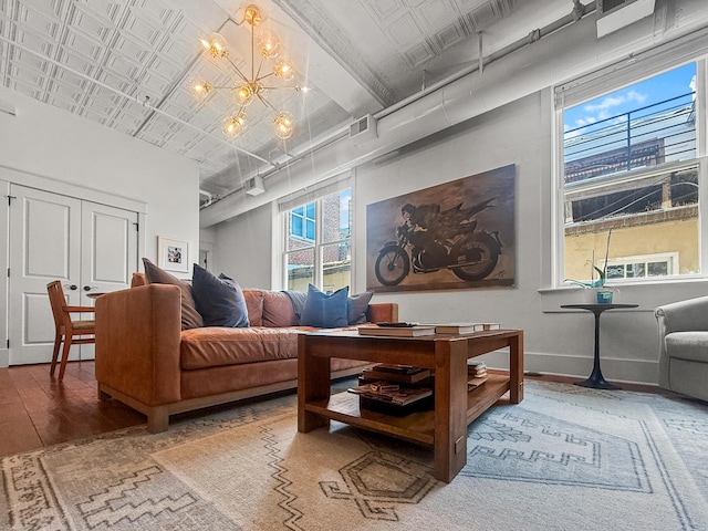 4 Beaufain St Unit 207, Charleston, SC 29401 - living area featuring hardwood / wood-style floors, a chandelier, an ornate ceiling, and a towering ceiling