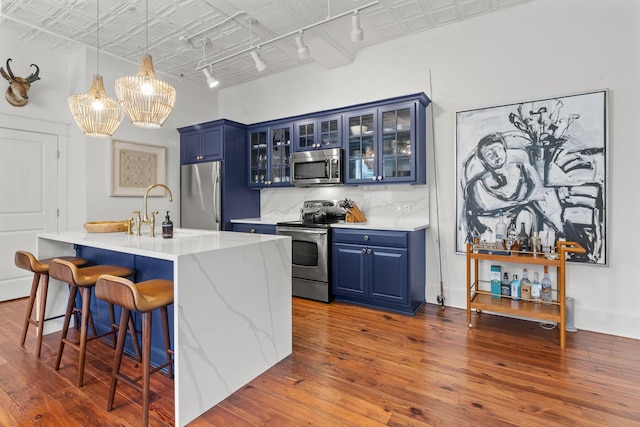 4 Beaufain St Unit 207, Charleston, SC 29401 - bar with appliances with stainless steel finishes, an ornate ceiling, dark wood finished floors, decorative light fixtures, and a chandelier