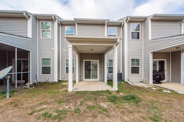 back of property featuring a lawn, central AC, a patio, and a sunroom