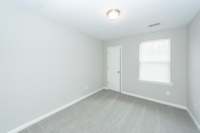 spare room featuring visible vents, baseboards, and carpet floors