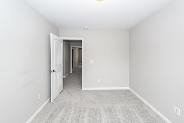 unfurnished room with carpet flooring and baseboards