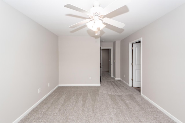 unfurnished room with carpet flooring, baseboards, and a ceiling fan