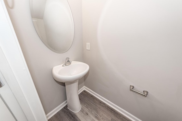 bathroom with wood finished floors, baseboards, and a sink