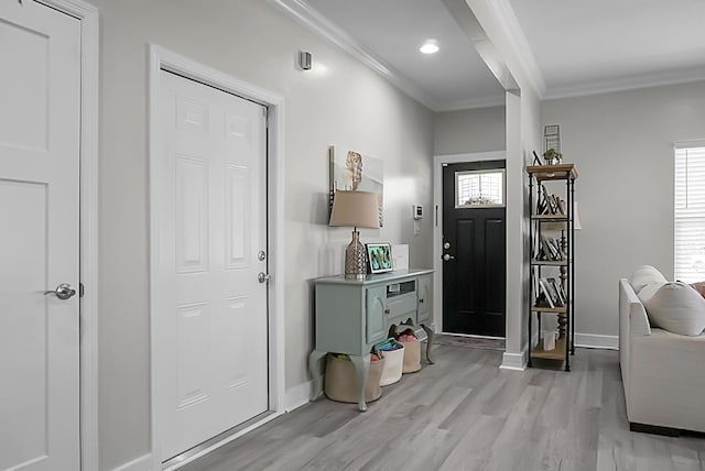 foyer featuring a healthy amount of sunlight, ornamental molding, and light hardwood / wood-style flooring