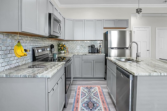 kitchen featuring sink, crown molding, gray cabinets, appliances with stainless steel finishes, and hanging light fixtures