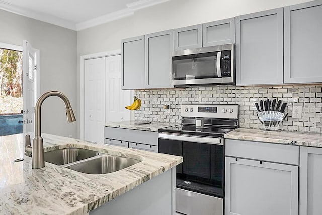 kitchen featuring appliances with stainless steel finishes, sink, and light stone counters