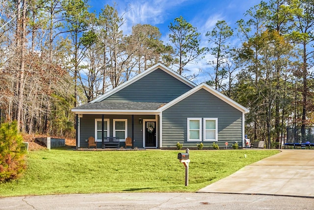 view of front of home featuring a trampoline, a front lawn, and a porch