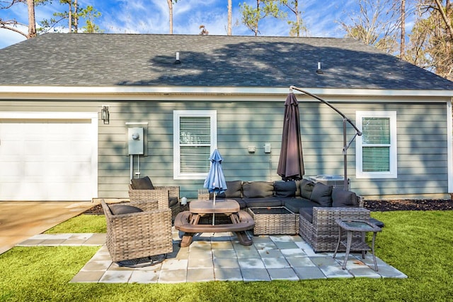 rear view of house featuring a garage, outdoor lounge area, a yard, and a patio area