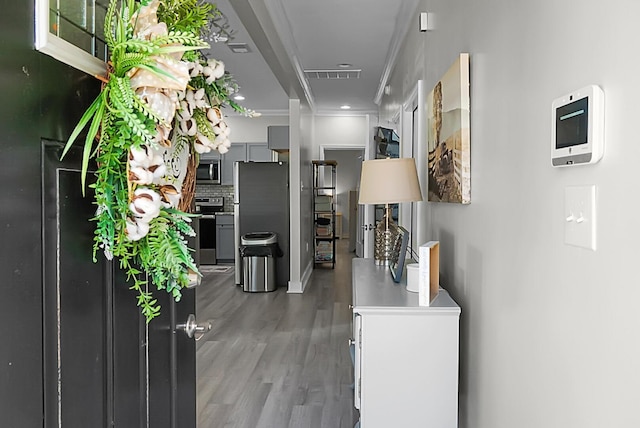 hallway with ornamental molding and hardwood / wood-style floors