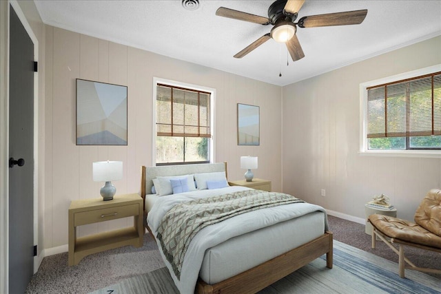 carpeted bedroom with ceiling fan and ornamental molding