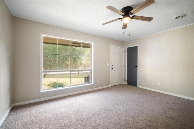 unfurnished room with carpet flooring, ceiling fan, a textured ceiling, and ornamental molding