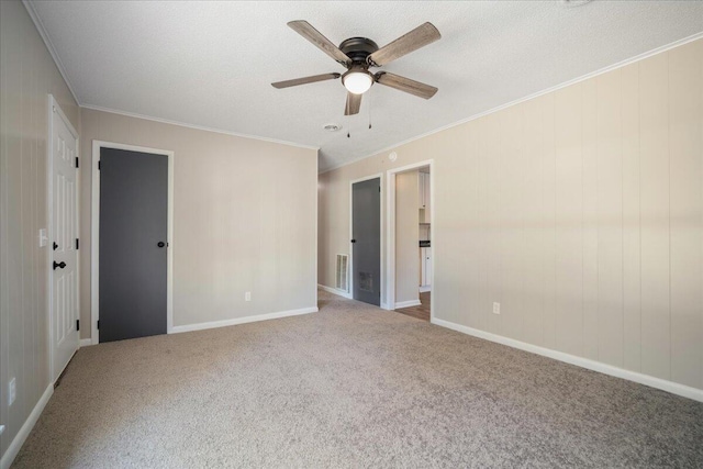 carpeted empty room with ceiling fan, crown molding, and a textured ceiling