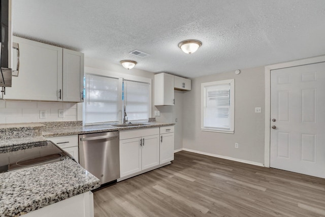 kitchen with dishwasher, white cabinets, light wood-type flooring, and sink