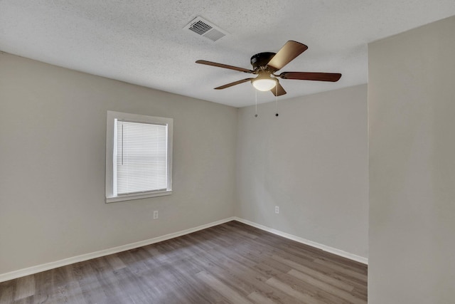 empty room with hardwood / wood-style floors, ceiling fan, and a textured ceiling