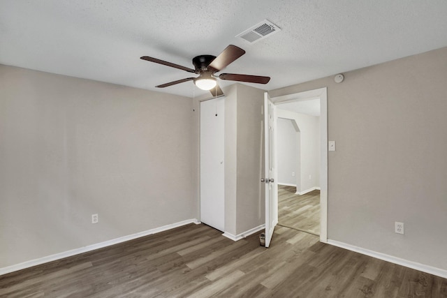 spare room featuring ceiling fan, dark hardwood / wood-style flooring, and a textured ceiling