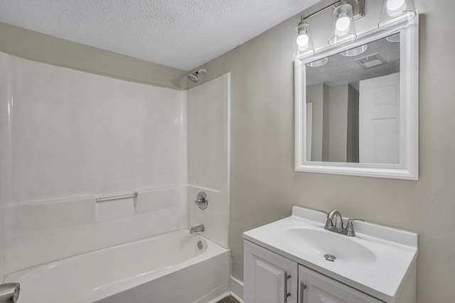 bathroom featuring vanity, shower / bathtub combination, and a textured ceiling