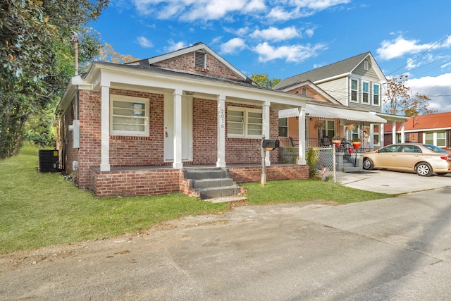 view of front facade with central AC unit, a porch, and a front yard