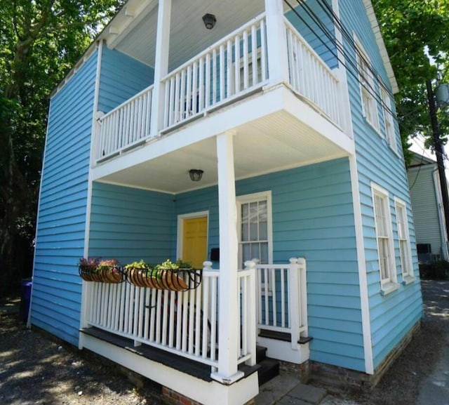 exterior space featuring covered porch and a balcony