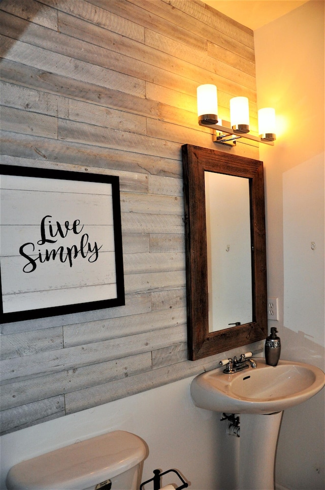 bathroom with wooden walls and toilet