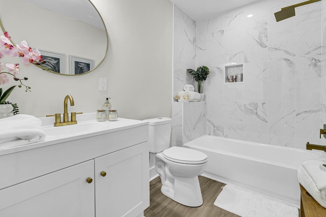 full bathroom featuring tiled shower / bath combo, hardwood / wood-style flooring, vanity, and toilet