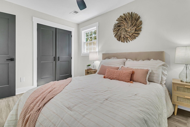 bedroom with light hardwood / wood-style floors, ceiling fan, and a closet