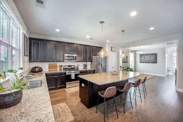 106 Sago Ct, Summerville, SC 29486 - kitchen with appliances with stainless steel finishes, a sink, a breakfast bar, a center island, and light stone counters