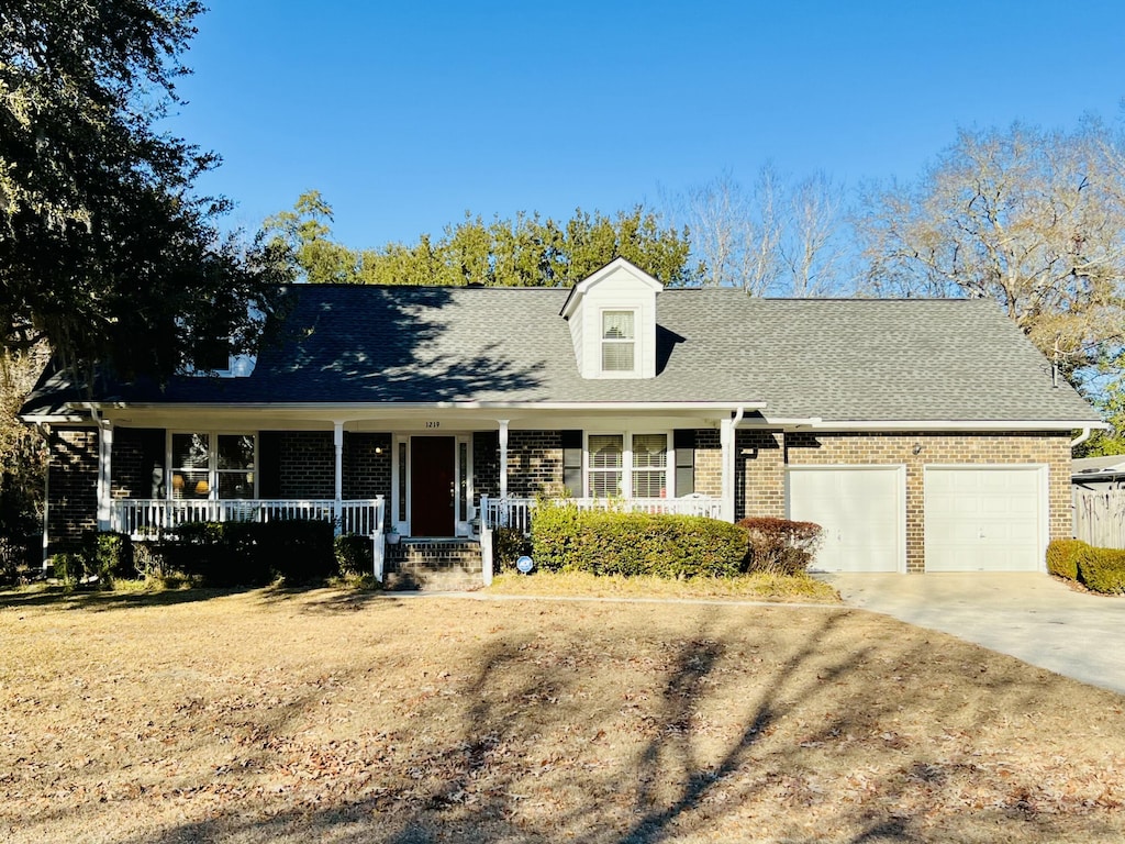 new england style home with a garage and covered porch