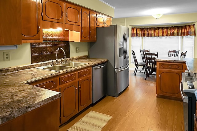 kitchen with stainless steel appliances, light hardwood / wood-style floors, and sink