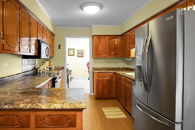 kitchen with ornamental molding, appliances with stainless steel finishes, kitchen peninsula, dark stone counters, and light hardwood / wood-style floors