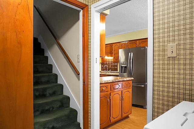 stairway with sink, hardwood / wood-style floors, and a textured ceiling