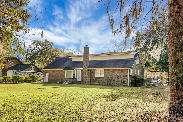 rear view of property with a lawn