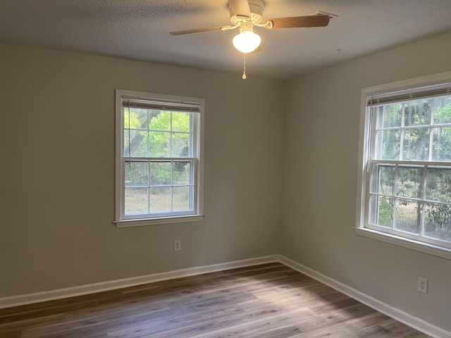 spare room with wood finished floors, ceiling fan, and baseboards