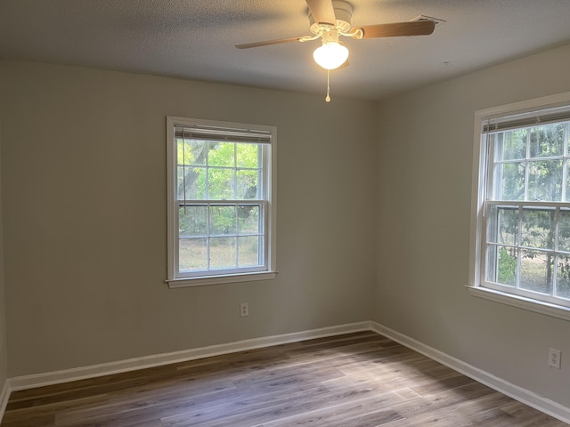 spare room featuring wood finished floors, ceiling fan, and baseboards