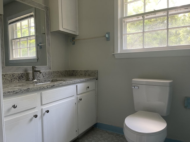 bathroom featuring toilet, plenty of natural light, and vanity