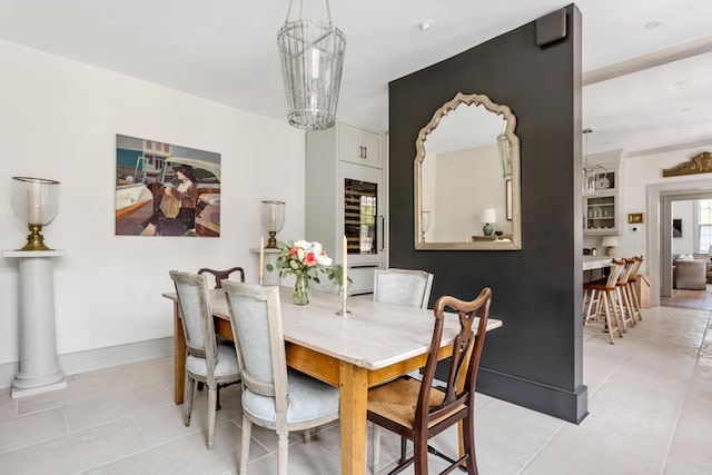 dining room featuring light tile patterned flooring, baseboards, and a chandelier