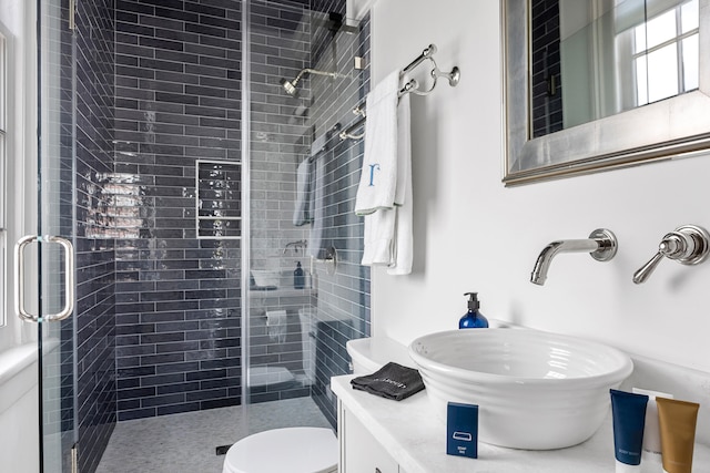 full bathroom with vanity, a shower stall, and toilet