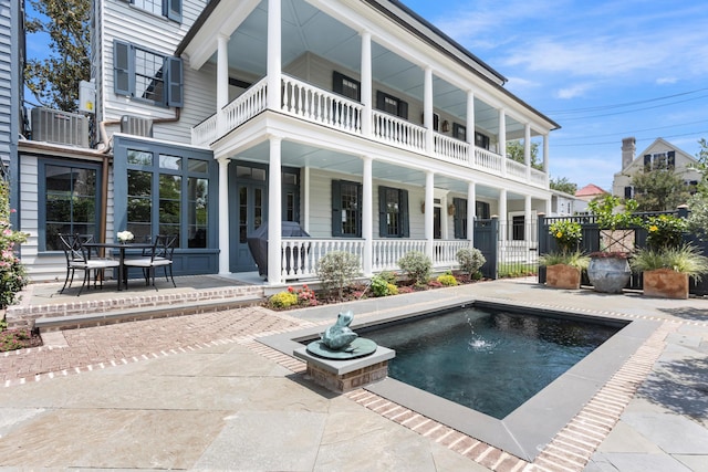 rear view of property with a patio, central air condition unit, and covered porch