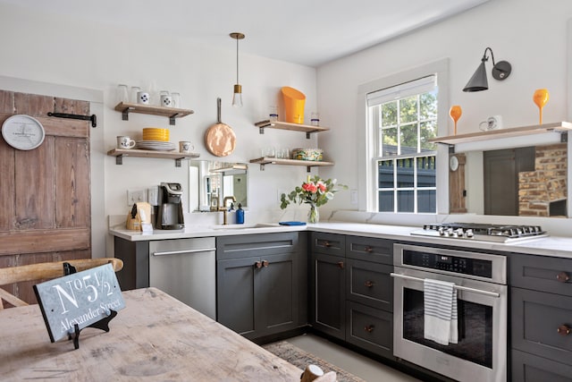 kitchen with open shelves, stainless steel appliances, gray cabinets, and a sink