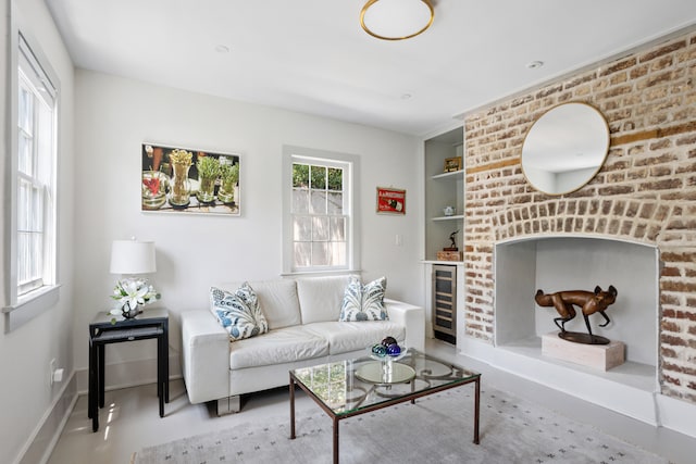 living room with wine cooler, built in shelves, and baseboards