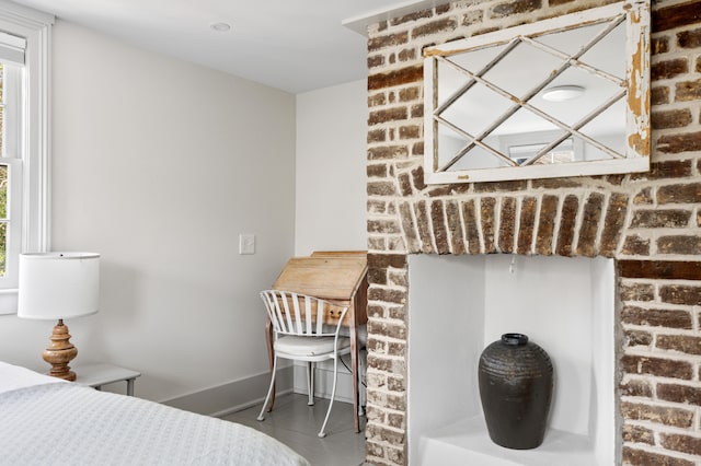 bedroom with brick wall and baseboards