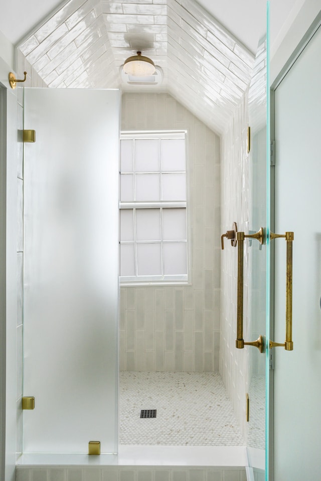 bathroom featuring a shower stall and lofted ceiling