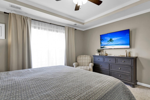 carpeted bedroom featuring ornamental molding, ceiling fan, and a tray ceiling