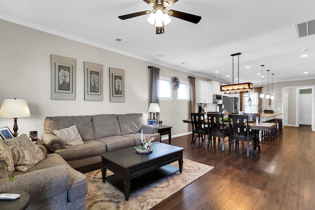 living room with dark wood-type flooring, ceiling fan, and ornamental molding