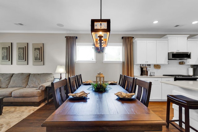 dining room with crown molding and dark hardwood / wood-style floors