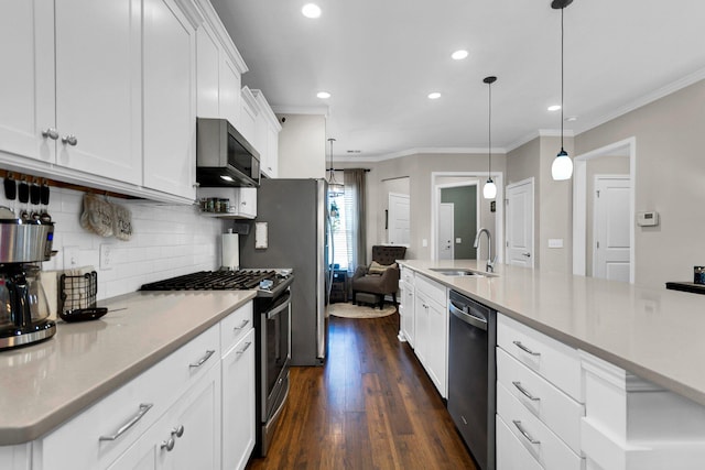 kitchen with pendant lighting, sink, appliances with stainless steel finishes, white cabinets, and decorative backsplash