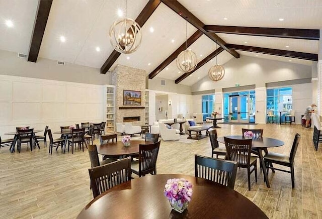 dining room with an inviting chandelier, a fireplace, high vaulted ceiling, and beam ceiling