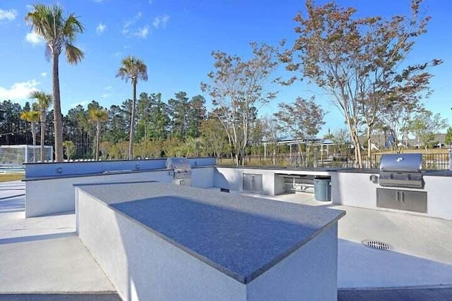 view of patio / terrace featuring exterior kitchen and a grill