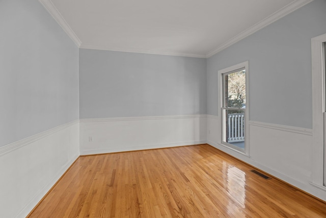 spare room with crown molding and light hardwood / wood-style flooring