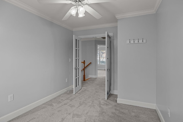 carpeted spare room with crown molding and ceiling fan